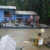 Residents wait to be evacuated from a partially submerged house during flooding in Bocaue, north of Manila.